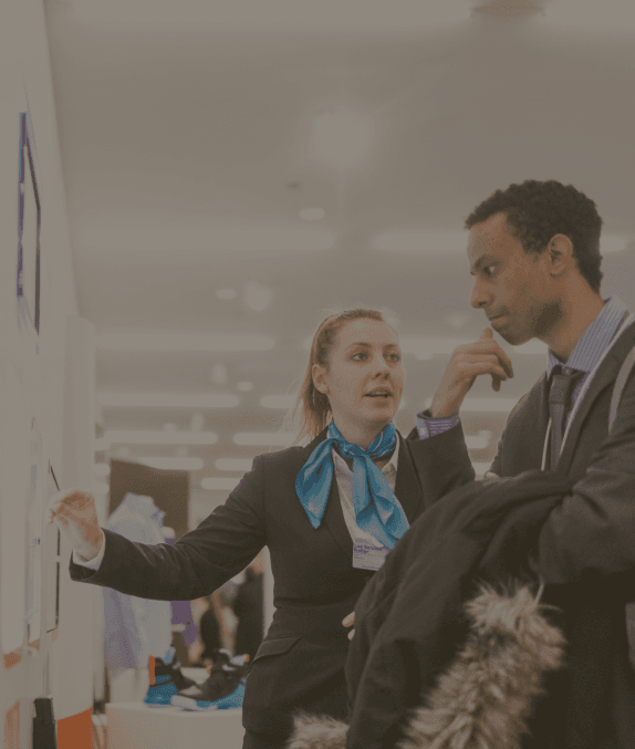 Two people in office setting looking at a whiteboard